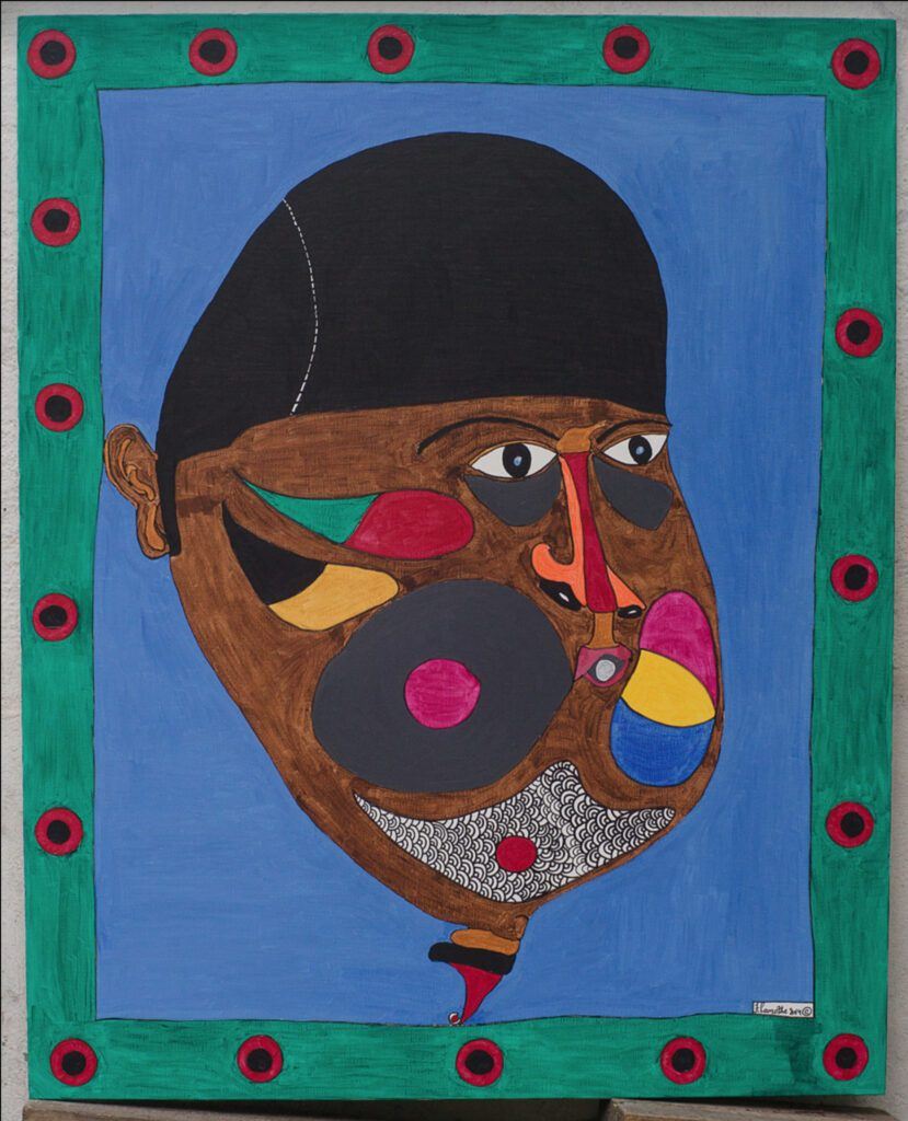 Untitled: a large head on a blue ground inside a painted green border of red dots, work by Frantz Lamothe
